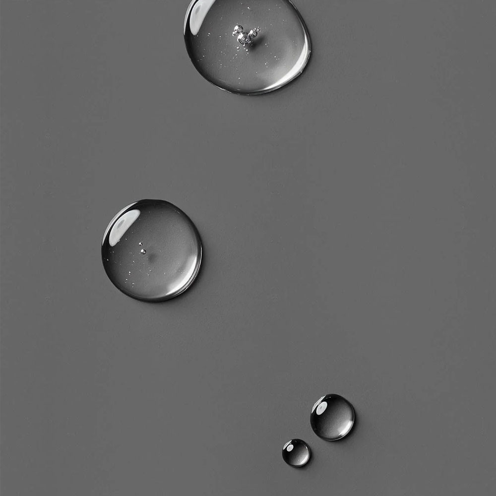 Clear lotion droplets on a gray surface