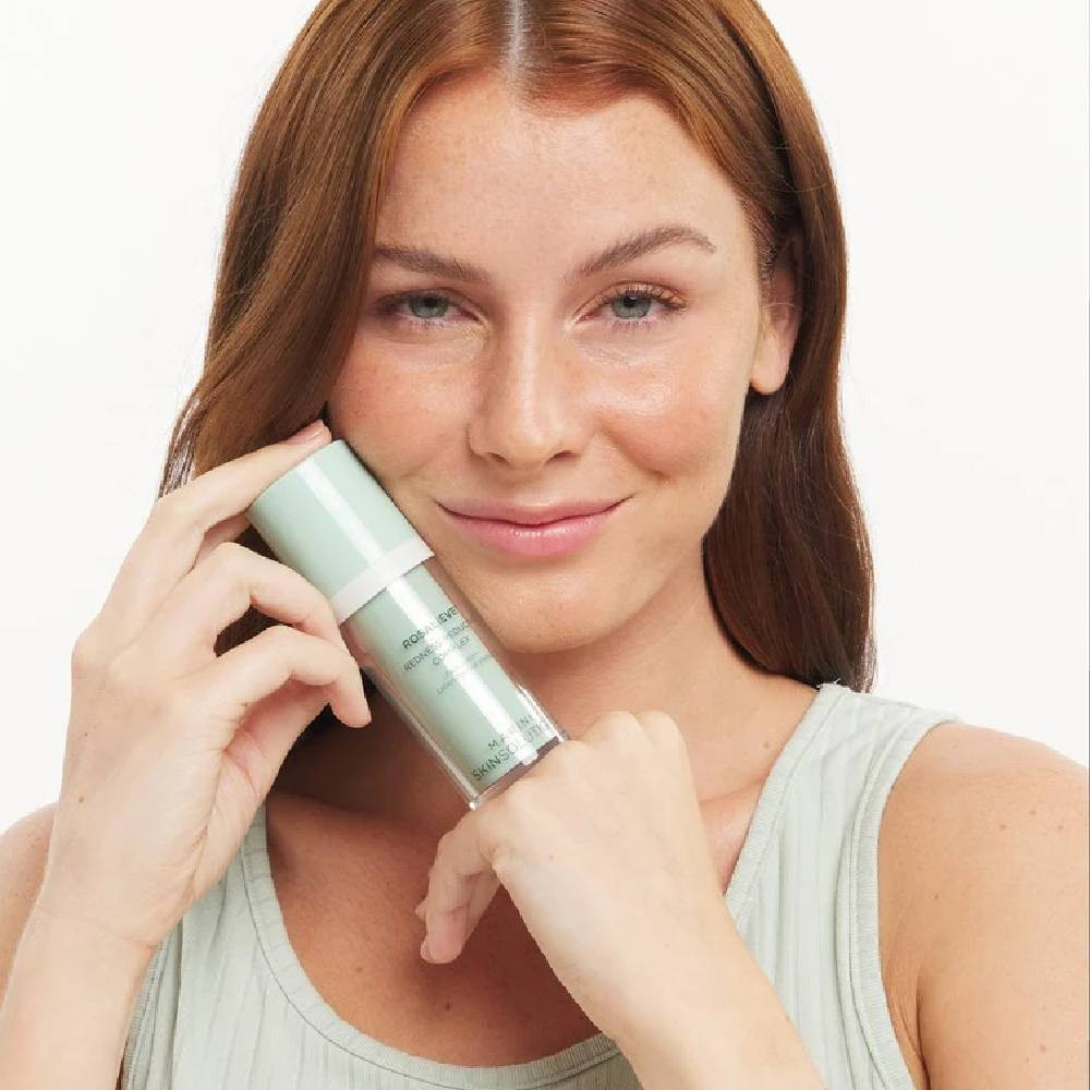 Smiling woman holding the RosaLieve bottle to her cheek