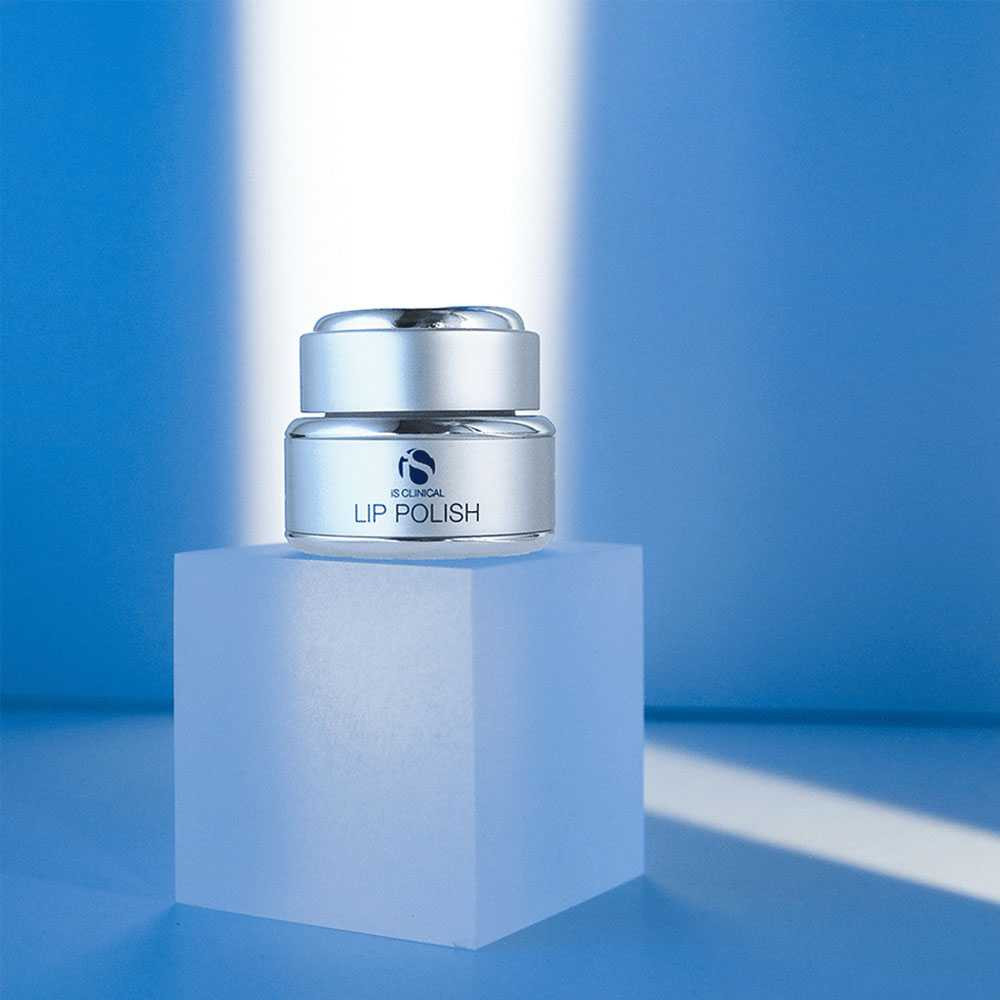 iS Clinical Lip Polish jar on a frosted pedestal in blue light