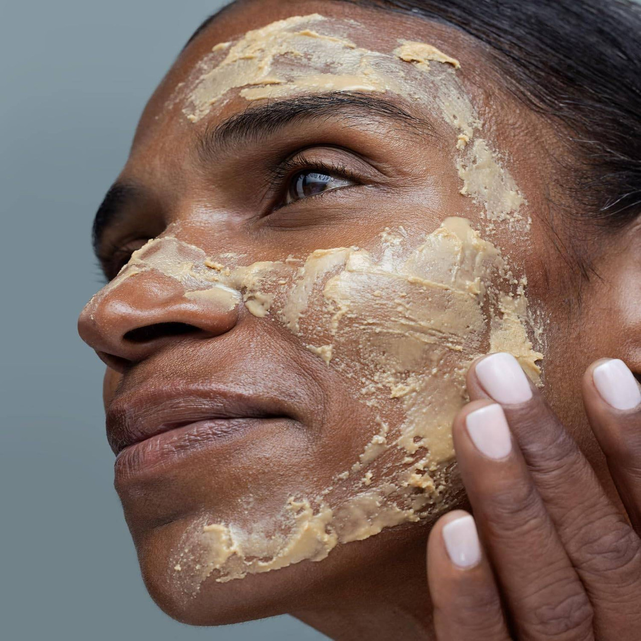Woman with yellow Polish + Mask applied across her face