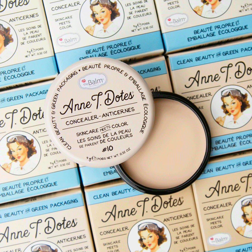 Open Anne T. Dotes Concealer compact on a stack of retro illustrated boxes