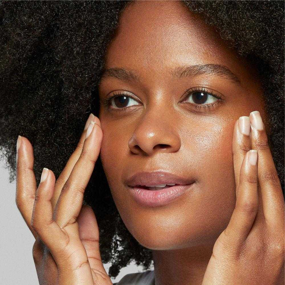 Woman pressing fingertips to her cheeks