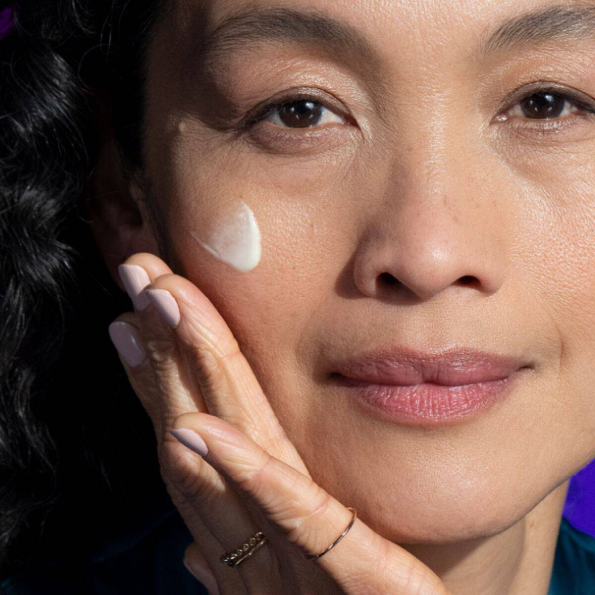 Woman applying StriVectin retinol serum to her cheek