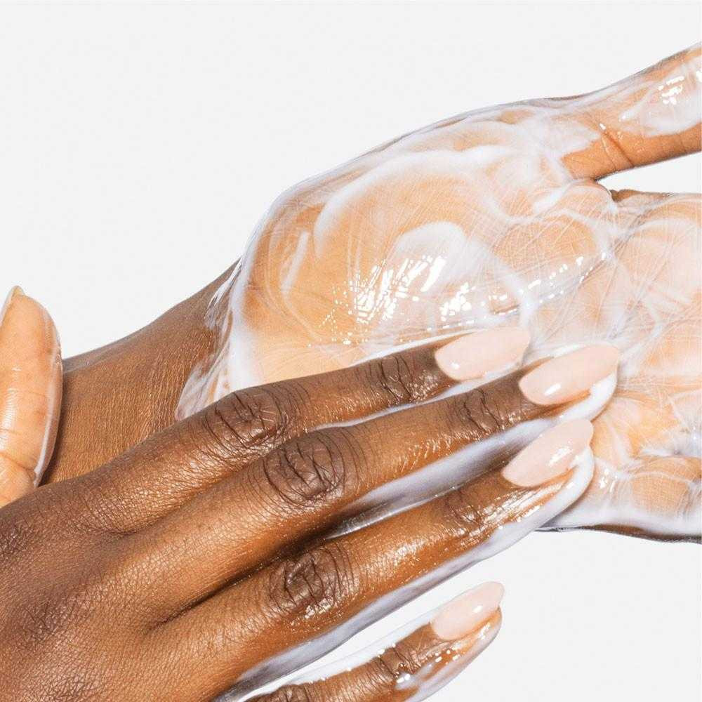 Hands massaging the cleanser into a light emulsion