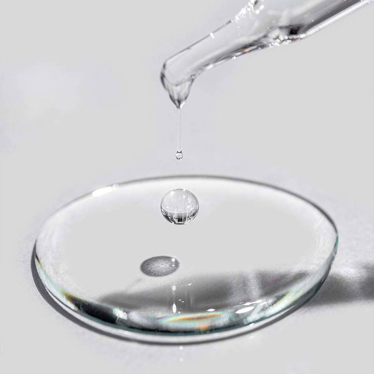 Dropper releasing a drop into a pool of oil
