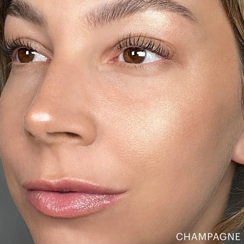 Model wearing Skin Glow Powder Highlighter in Champagne on the cheekbone