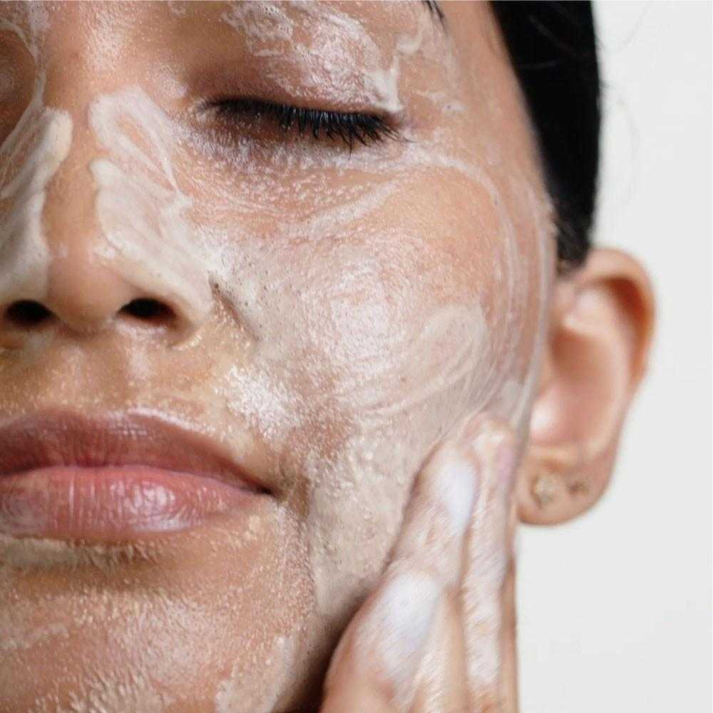 Woman massaging foamy cleanser onto her face