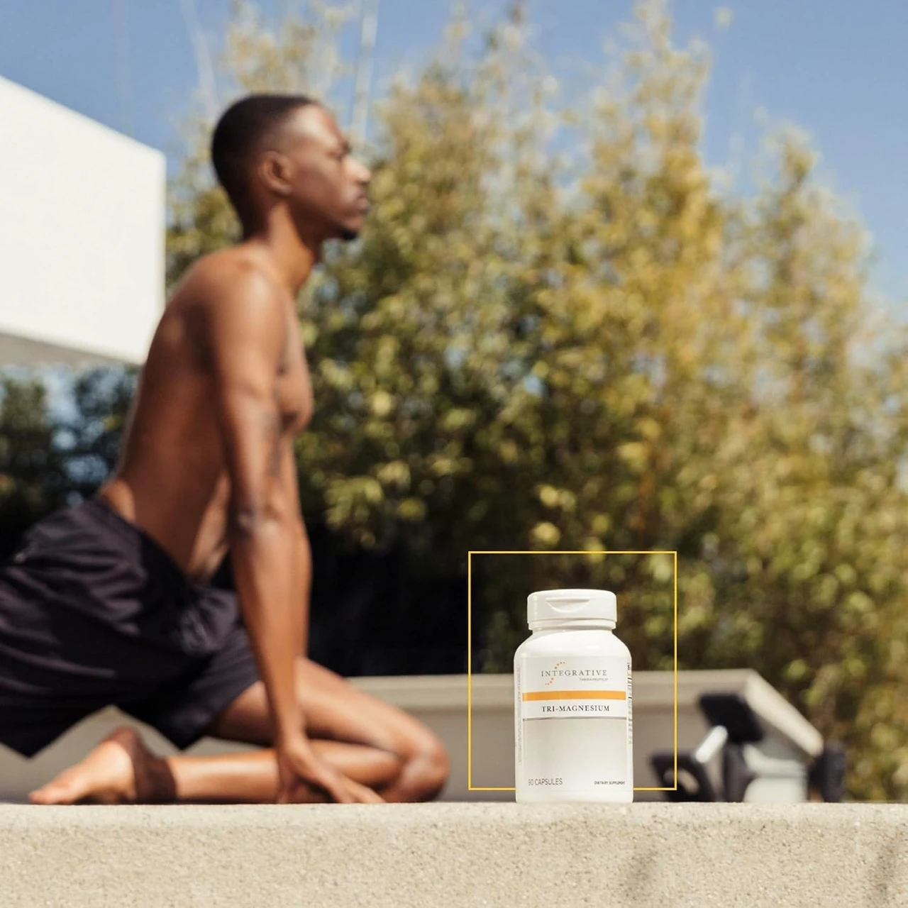 Man stretching outdoors beside an Integrative Therapeutics bottle