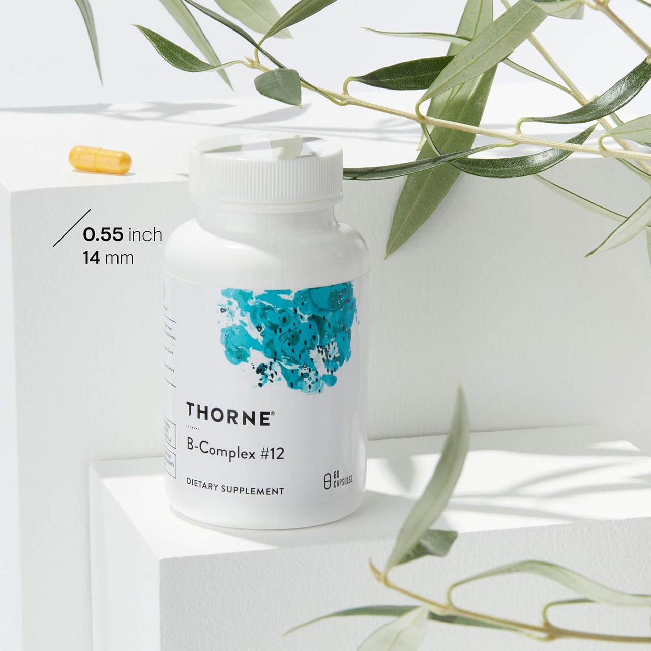 B-Complex #12 bottle with capsule size marker among leaves