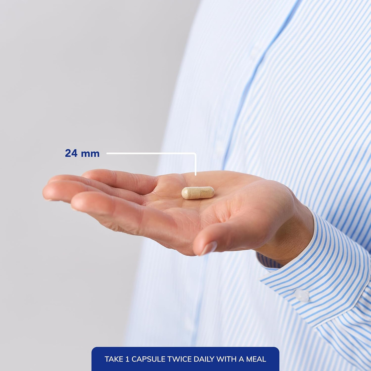 Capsule in an open palm, 24 mm, take 1 capsule twice daily with a meal