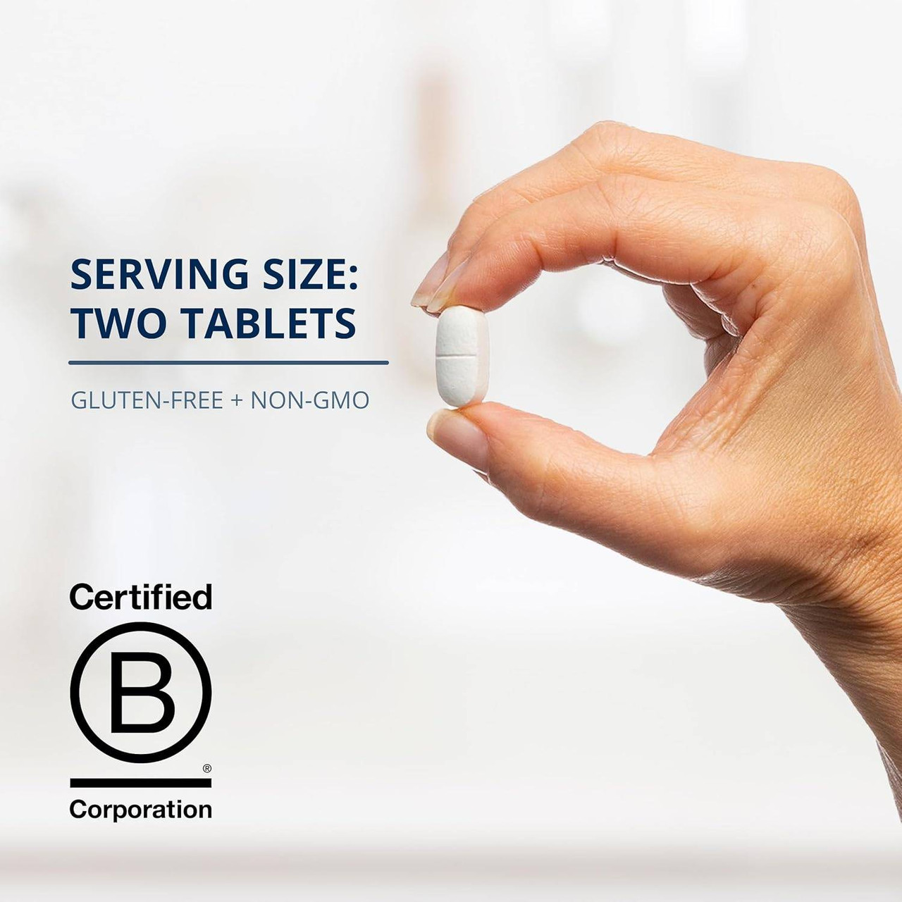Hand holding a tablet with serving size two tablets text