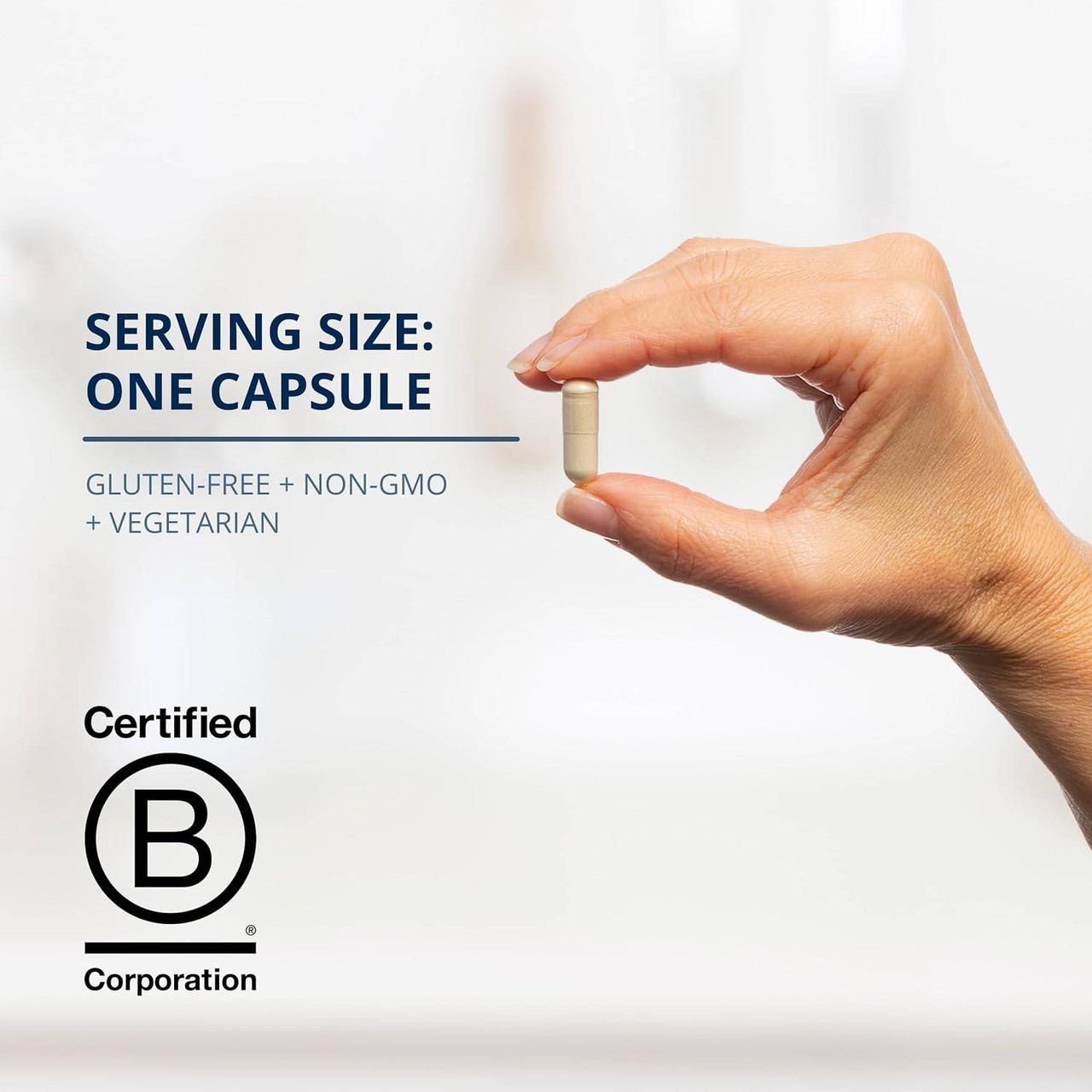 Hand holding one capsule with serving size text and B Corp logo