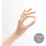 Fingers holding a capsule beside a 1.9 cm size marker