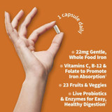 Hand holding a capsule, 1 capsule daily, 22 mg whole food iron with vitamins C, B-12 and folate