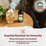 Person with glass and Immune Support bottle, 95 mg oleuropein, 1 tablespoon daily