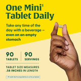 Hand holding mini tablet, one mini tablet daily, 60 tablets, 60 servings