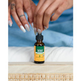 Hands squeezing a dropper on a Herb Pharm Reishi bottle