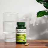 Sweet Ease bottle and tablets beside a glass of water