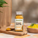 Kitchari Spice Mix jar beside bowls of spices and prepared kitchari
