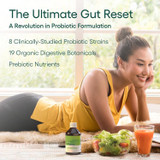 Woman with green juice beside probiotic bottles on a kitchen counter