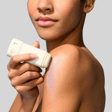 Woman applying HydroPeptide Sun Slick sun stick to her shoulder