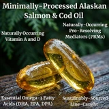Two fish oil softgels on wood with salmon and cod oil text