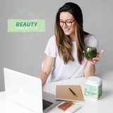 Woman at laptop with green juice, Beauty Greens beauty from within graphic