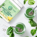 Beauty Greens tub with two green smoothie glasses and leaves flat lay graphic