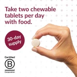 Hand holding a chewable tablet with take two per day text