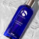 iS Clinical Cleansing Complex bottle lying in rippling water