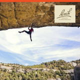 Rock climber on an overhanging cliff with Bach logo