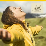Woman in yellow jacket smiling with eyes closed, Bach lifestyle graphic