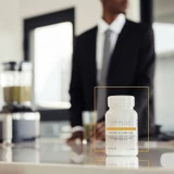 Man holding an Active B-Complex bottle in a hotel lobby