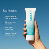 Hand holding the Coola Mineral Body Lotion SPF 30 tube with key benefits
