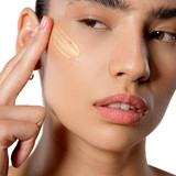 Woman applying serum to her cheekbone