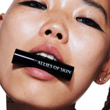 Model holding the lip balm in her mouth