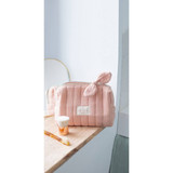 Bachca Paris pink quilted makeup bag on marble counter with toothbrush