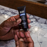 Hands dispensing clear Anti-Bump Treatment serum onto palm