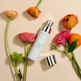 Hydrating Mist bottle lying among pink and orange flowers