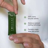 Hand holding a FODZYME stick pack with three feature callouts
