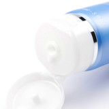 Close-up of white cleansing cream at the open tube cap