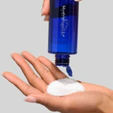 HydroPeptide Pre-Treatment Toner poured onto a cotton pad in hand