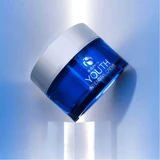 iS Clinical Youth Intensive Crème jar tilted on clear pedestal, blue light