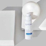 Glytone Enhance Brightening Complex bottle with white sphere on gray blocks
