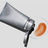 Open mask tube beside a dish of red-orange mask swatch