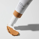 Tinted primer tube tilted over a swatch, casting a shadow