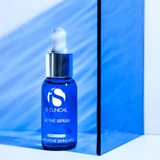 iS Clinical Active Serum dropper bottle on blue acrylic block