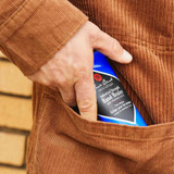 Hand slipping a Jack Black Hand Healer tube into a corduroy jacket pocket