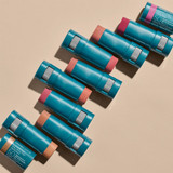 Rows of teal Sunforgettable Color Balm sticks in assorted shades on beige