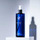 Youth Body Serum bottle on a white block with dramatic shadow